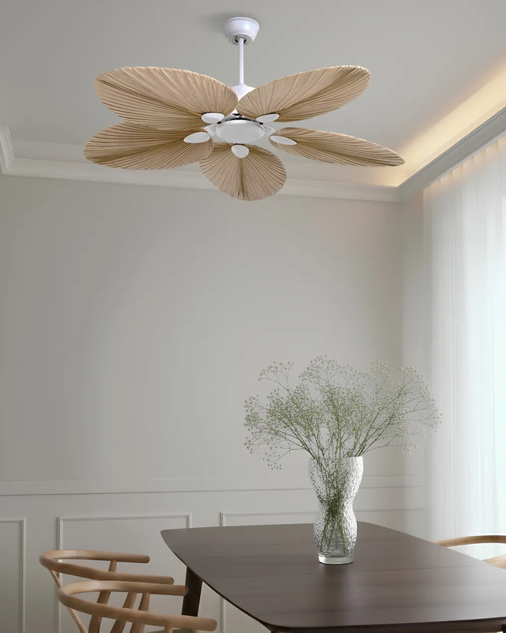 Ventilateur de plafond bohème en feuille de palmier LOMBOK par Ariaze installé dans une salle à manger épurée.